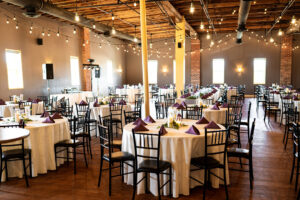 barn wedding with twinkle lights, white linens and black chivairi chairs