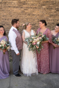 bride standing with wedding party holding bouquet