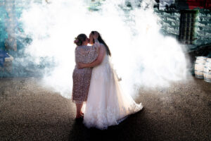 Two brides kissing in front of fireworks display