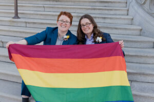 couple holding gay flag in washington d.c. smiling 